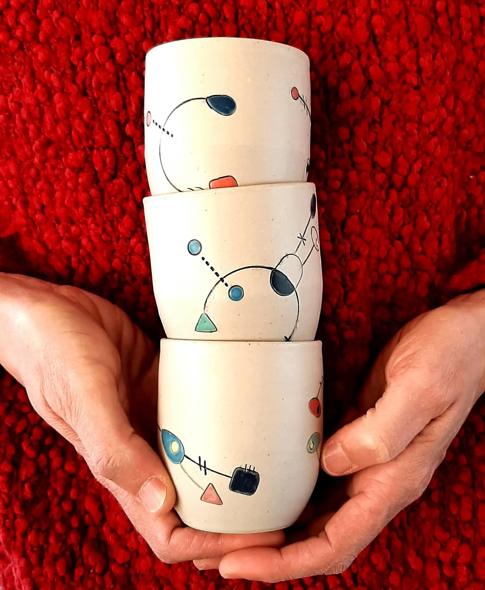 détails de mains portant trois tasses empilées-collection Geometrik