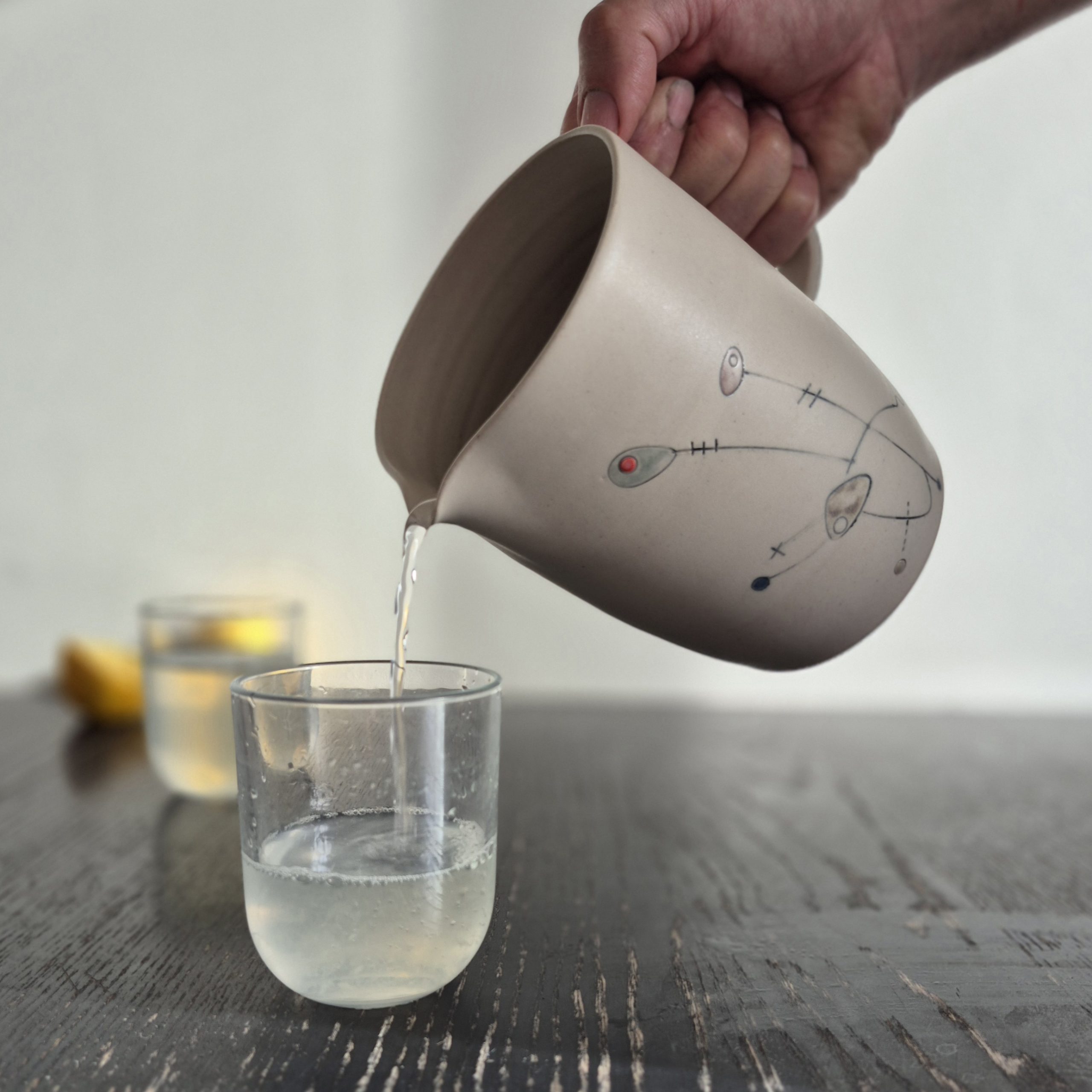 Pichet en céramique Géometrik fait main versant de l’eau dans un verre, fabrication artisanale à Grenoble