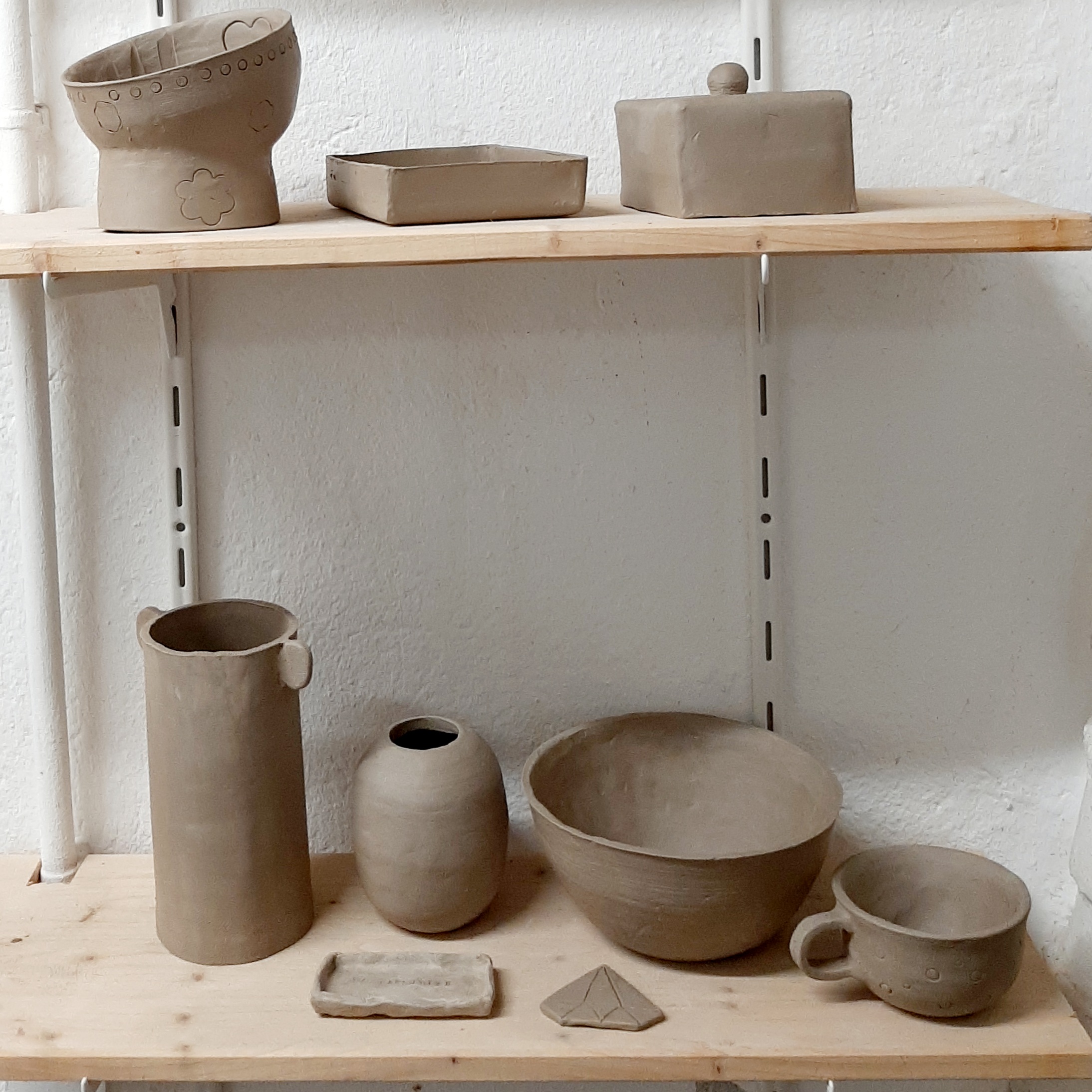 Créations réalisées par des débutants en train de sécher sur les étagères de l'Atelier Kaolin à Grenoble.