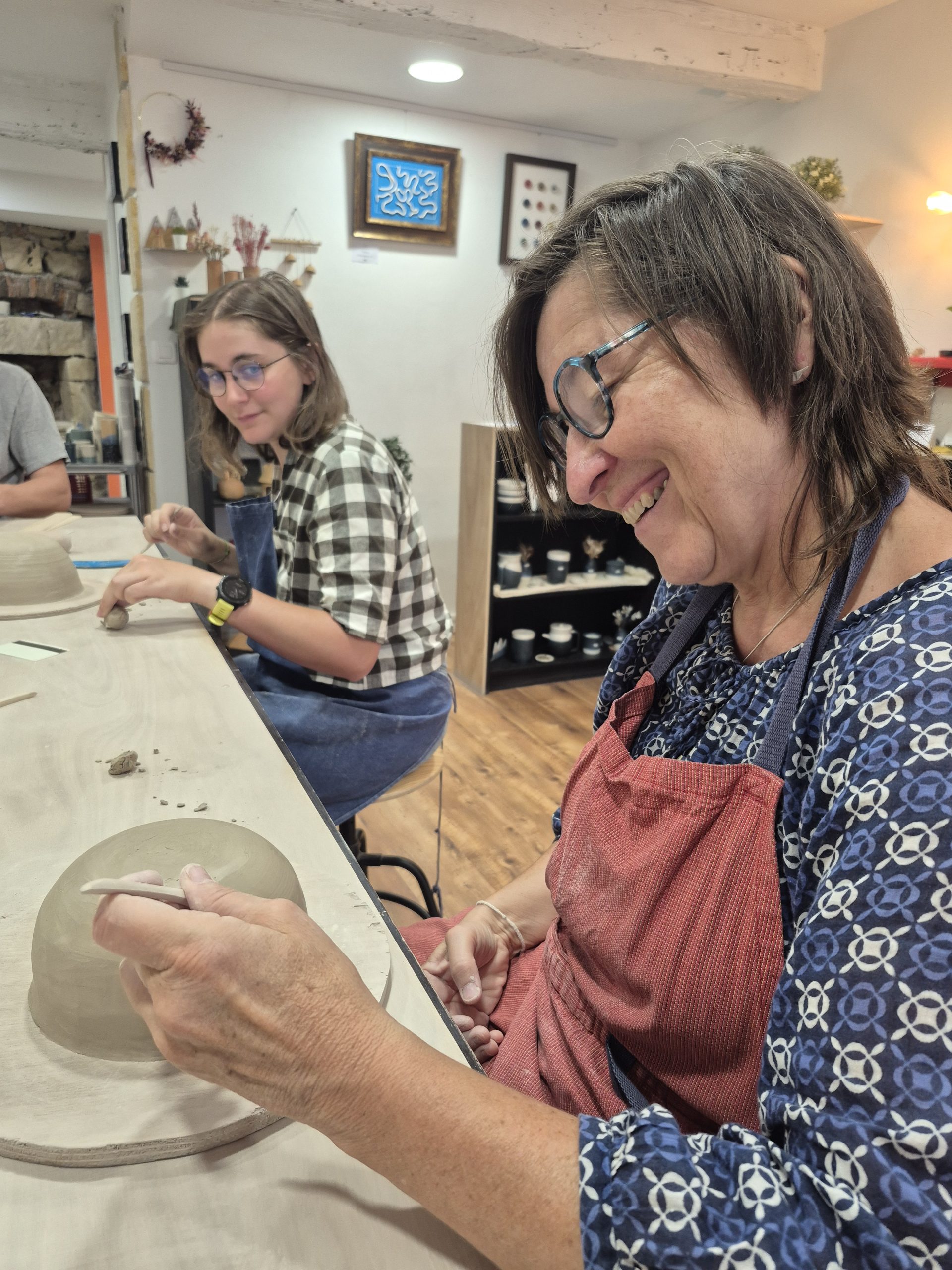 Débutante contemple sa première création en céramique réalisée lors d'un atelier de poterie à Grenoble