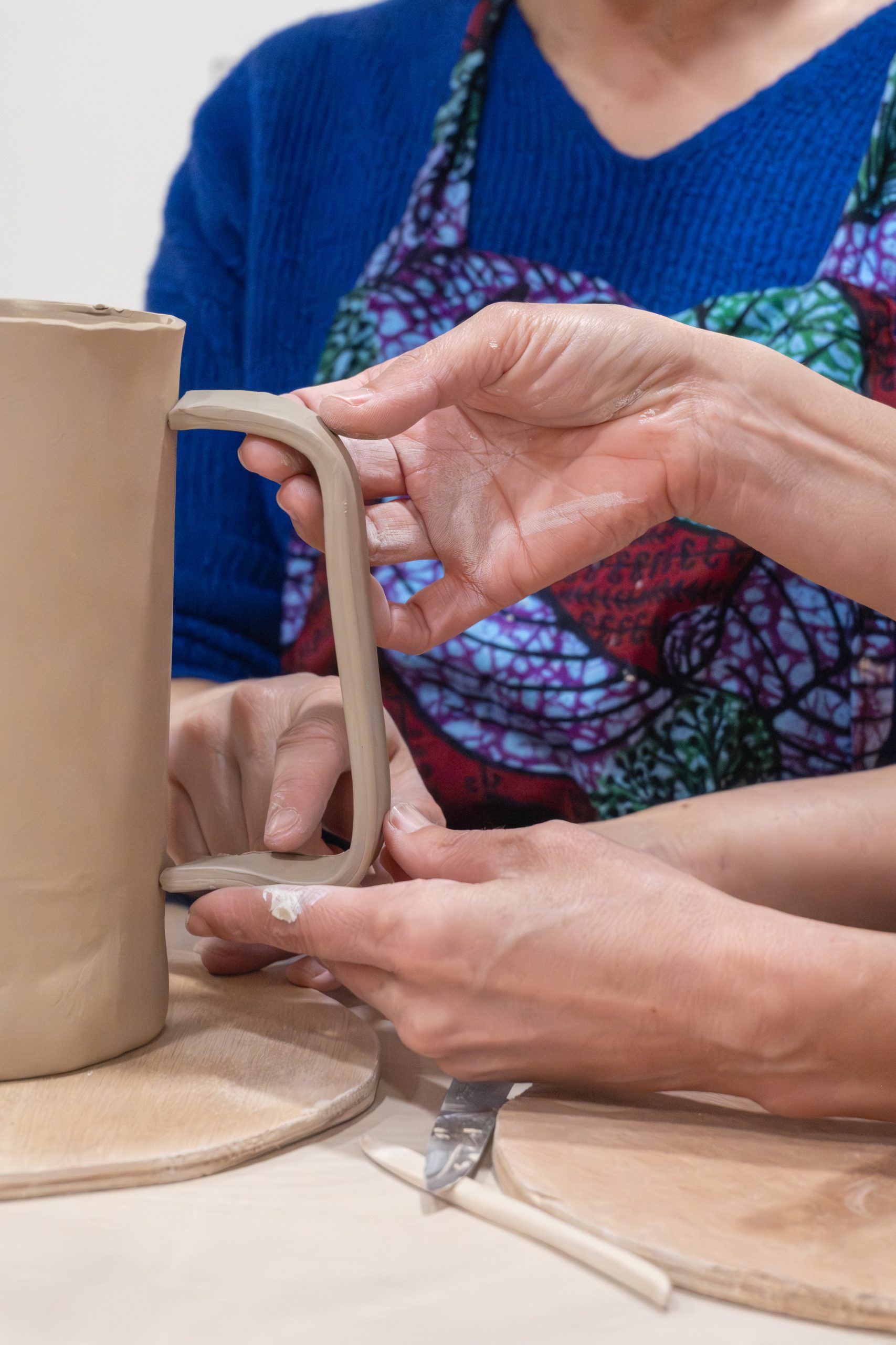 Carine accompagne une participante pendant son premier atelier de poterie à Grenoble